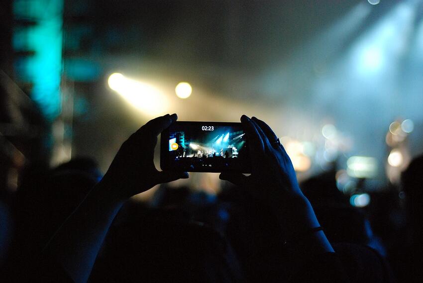 A guest filming on a phone at an event